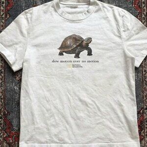 White graphic  featuring a "Slow Motion Over No Motion" turtle T - Shirt